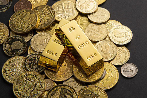 monedas-lingotes-oro-esparcidos-sobre-mesa